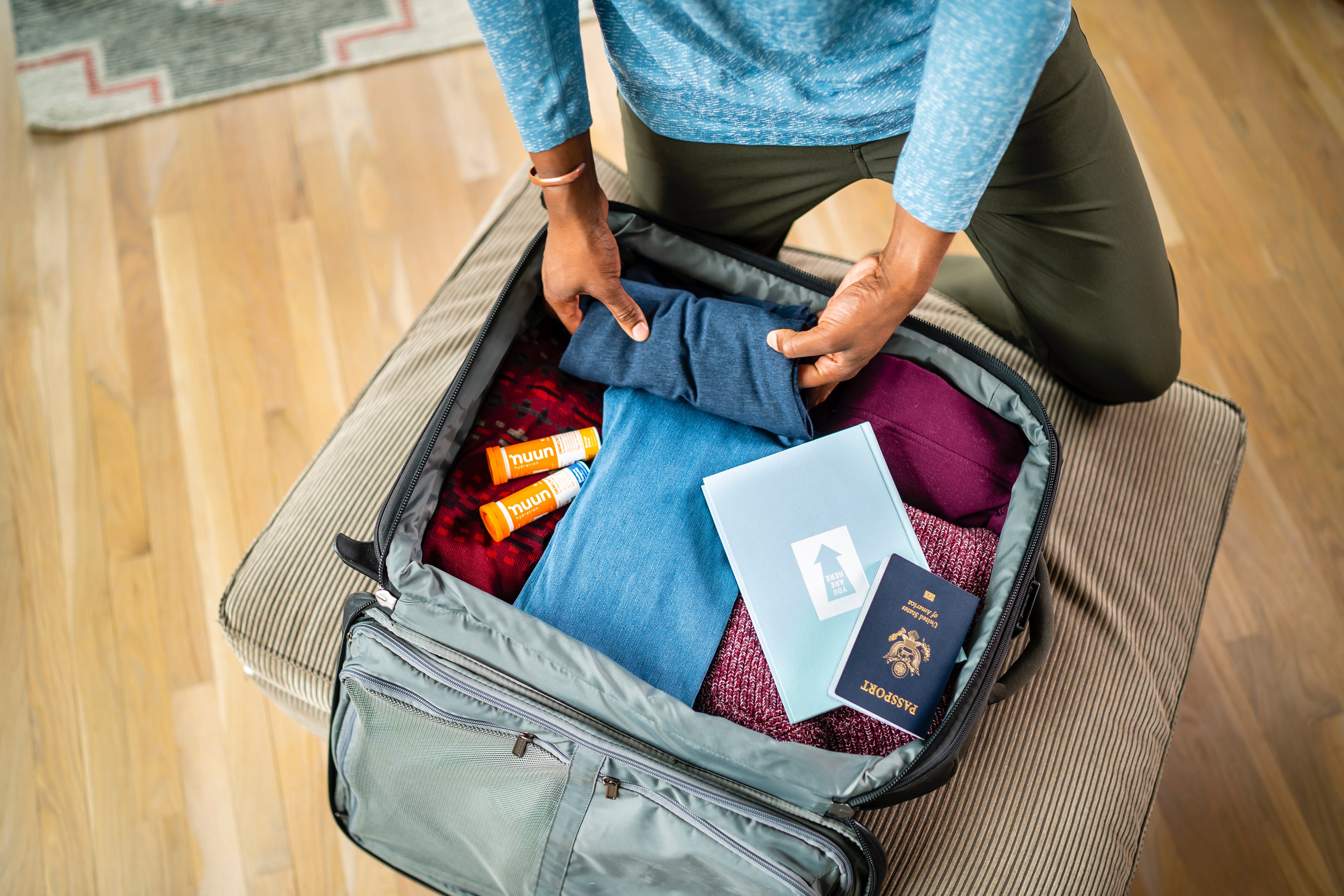 person packing a suitcase with nuun immunity in it