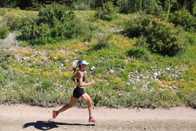 Grayson Murphy trail running by some wildflowers 