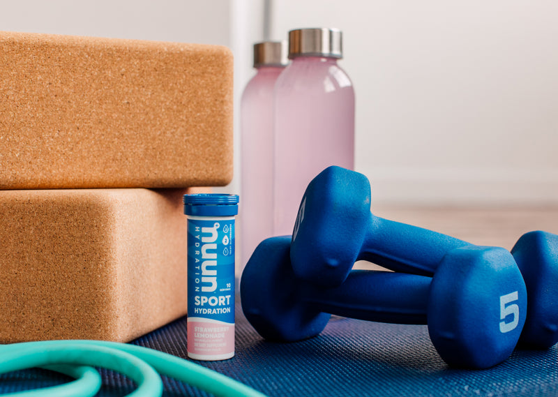 Nuun Sport next to a pair of dumbbells.